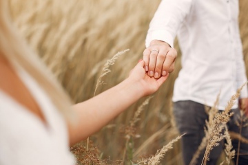 Cute couple in a field. Lady in a white dress. Guy in a white shirt