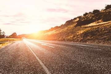 Picturesque landscape scene and sunrise above road