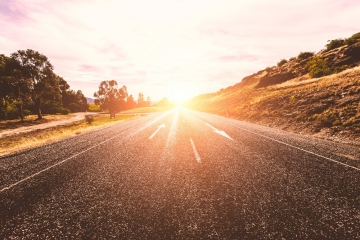 Picturesque landscape scene and sunrise above road