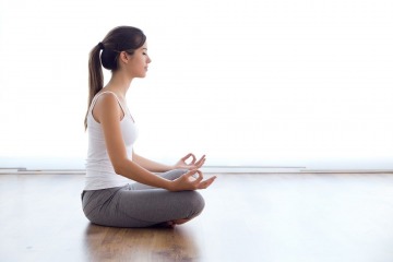 Portrait of beautiful young woman doing yoga exercises at home.